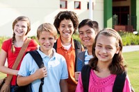 Children standing outside school with bookbags